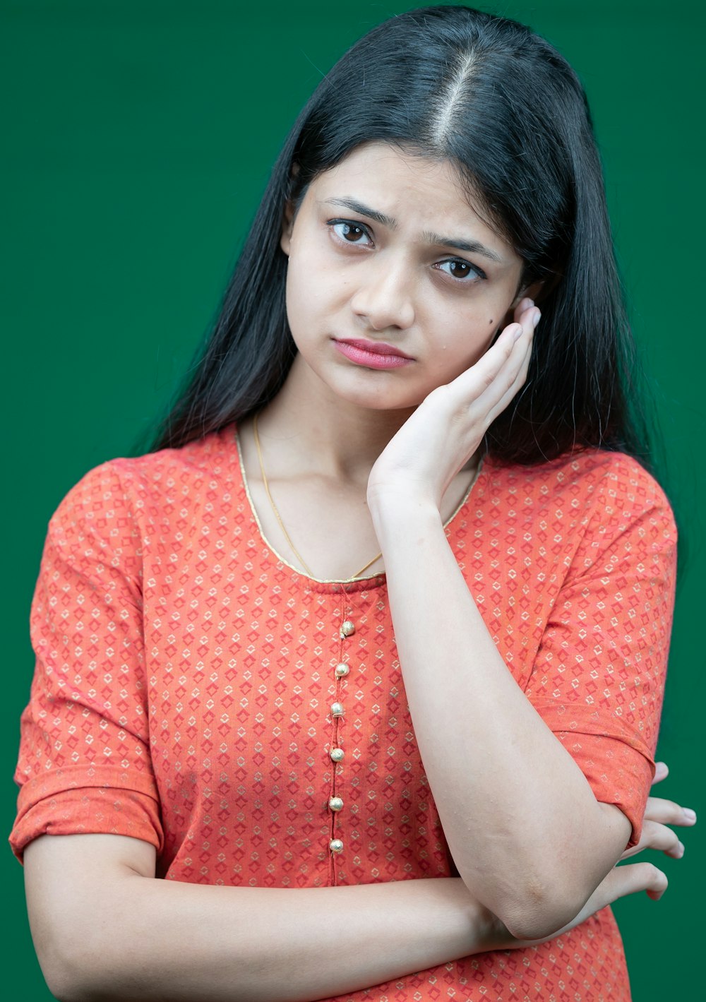 a woman in an orange top is posing for a picture