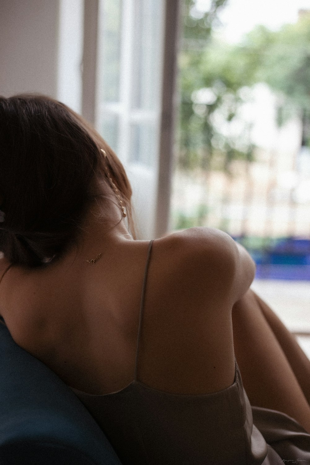 a woman sitting on a couch looking out a window