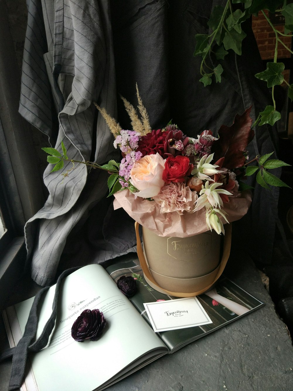 a flower pot sitting on top of a table next to an open book