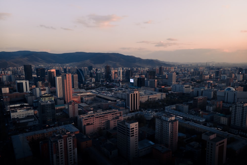 an aerial view of a city with mountains in the background