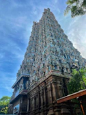 The serene temple surroundings of Vaitheeswaran Koil under a clear blue sky.