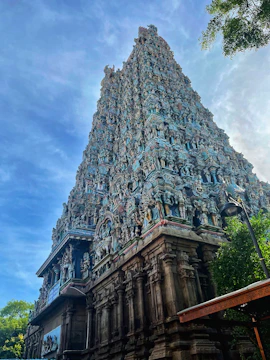 The majestic Shiva temple surrounded by lush greenery under a clear blue sky.