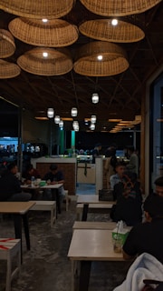 The cozy interior of rakizza, with wooden tables and soft lighting reflecting Madini-Hijazi culture.