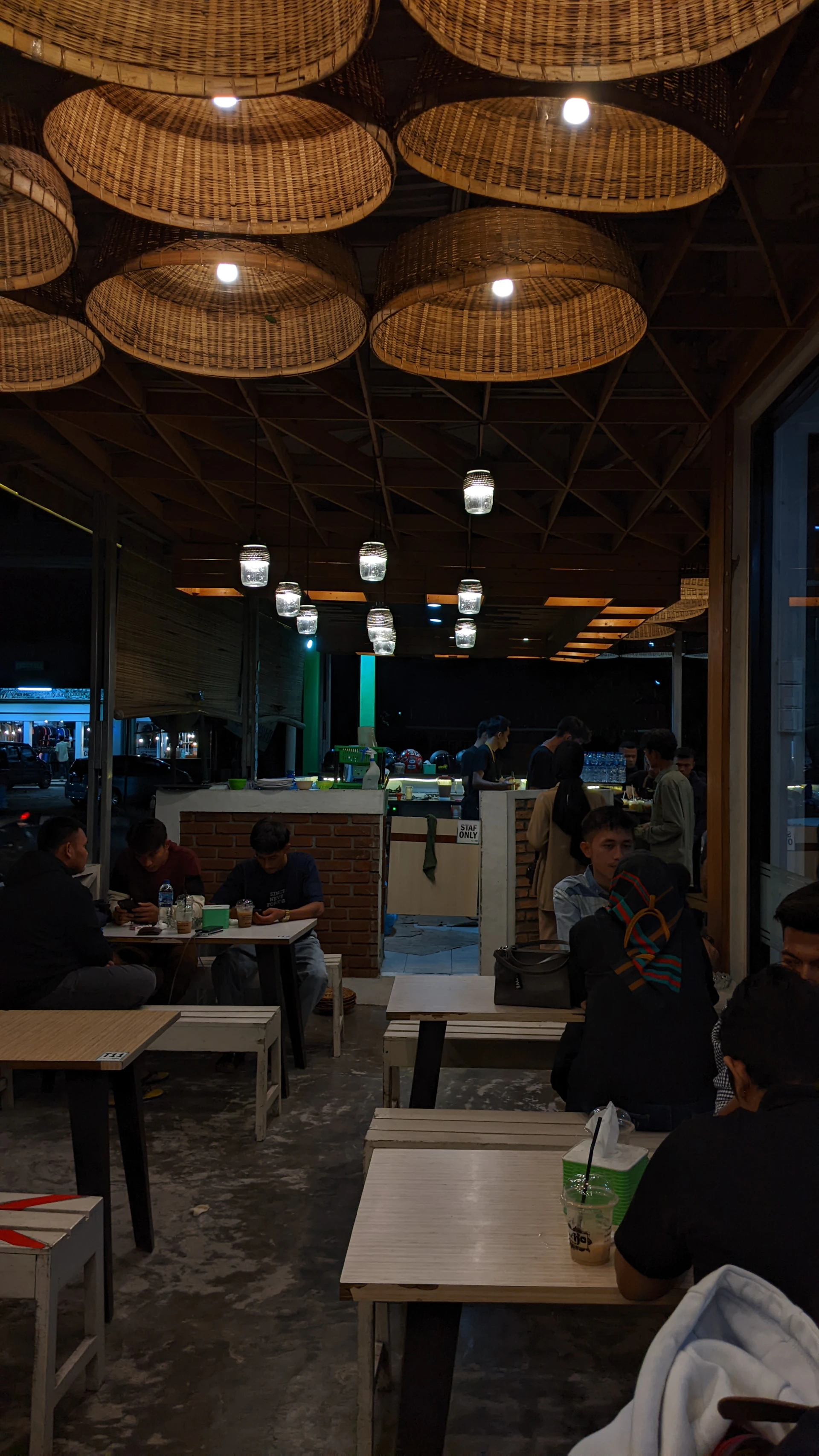 Guests enjoying a lively evening event in Pikanto's warmly decorated space with wooden accents.