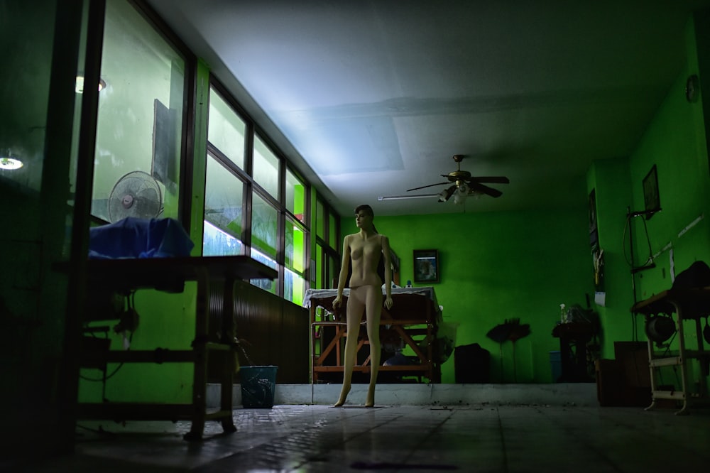 a naked man standing in a room with green walls