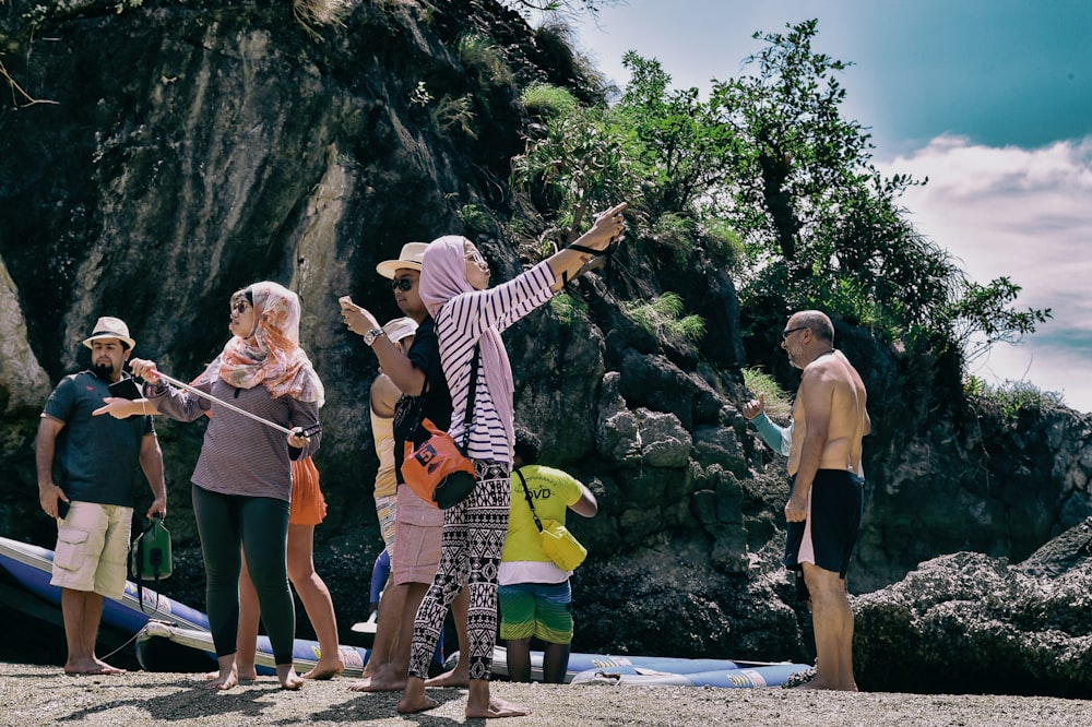 a group of people standing on top of a sandy beach