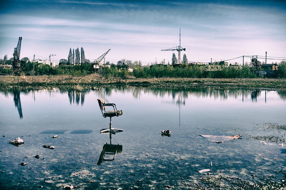 a chair sitting in the middle of a body of water