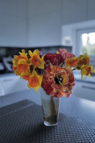 Bright kitchen corner with colorful dish towels and a vase of fresh flowers.