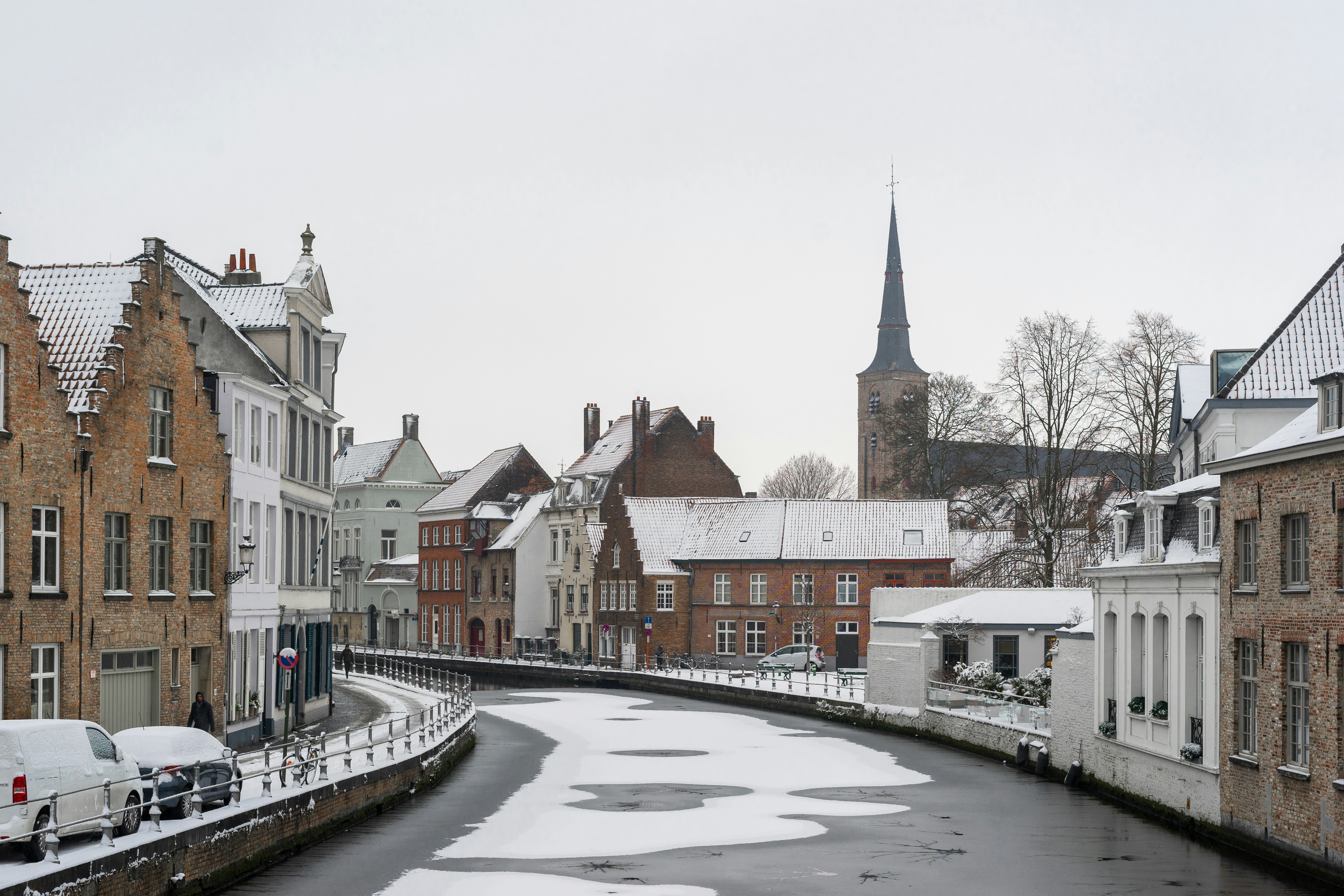 a river running through a city next to tall buildings, 
