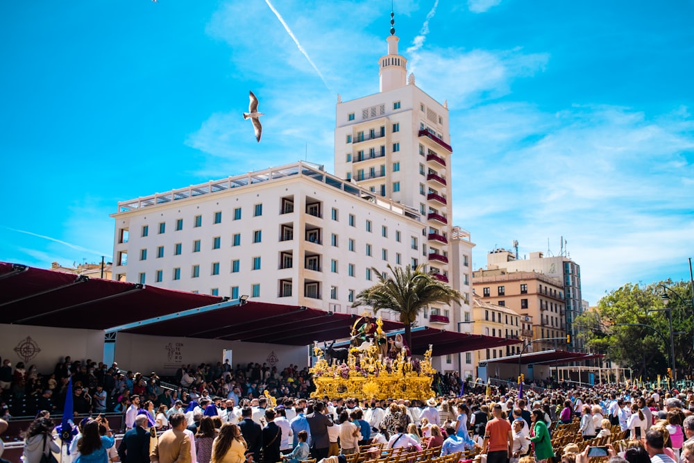 a crowd of people standing in front of a tall building