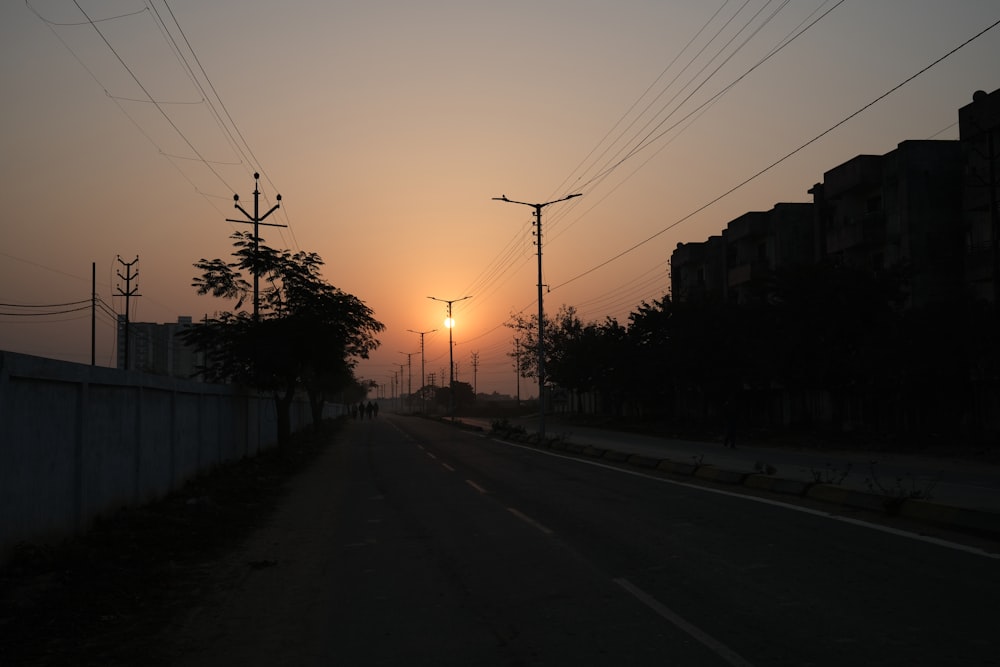 the sun is setting over a city street