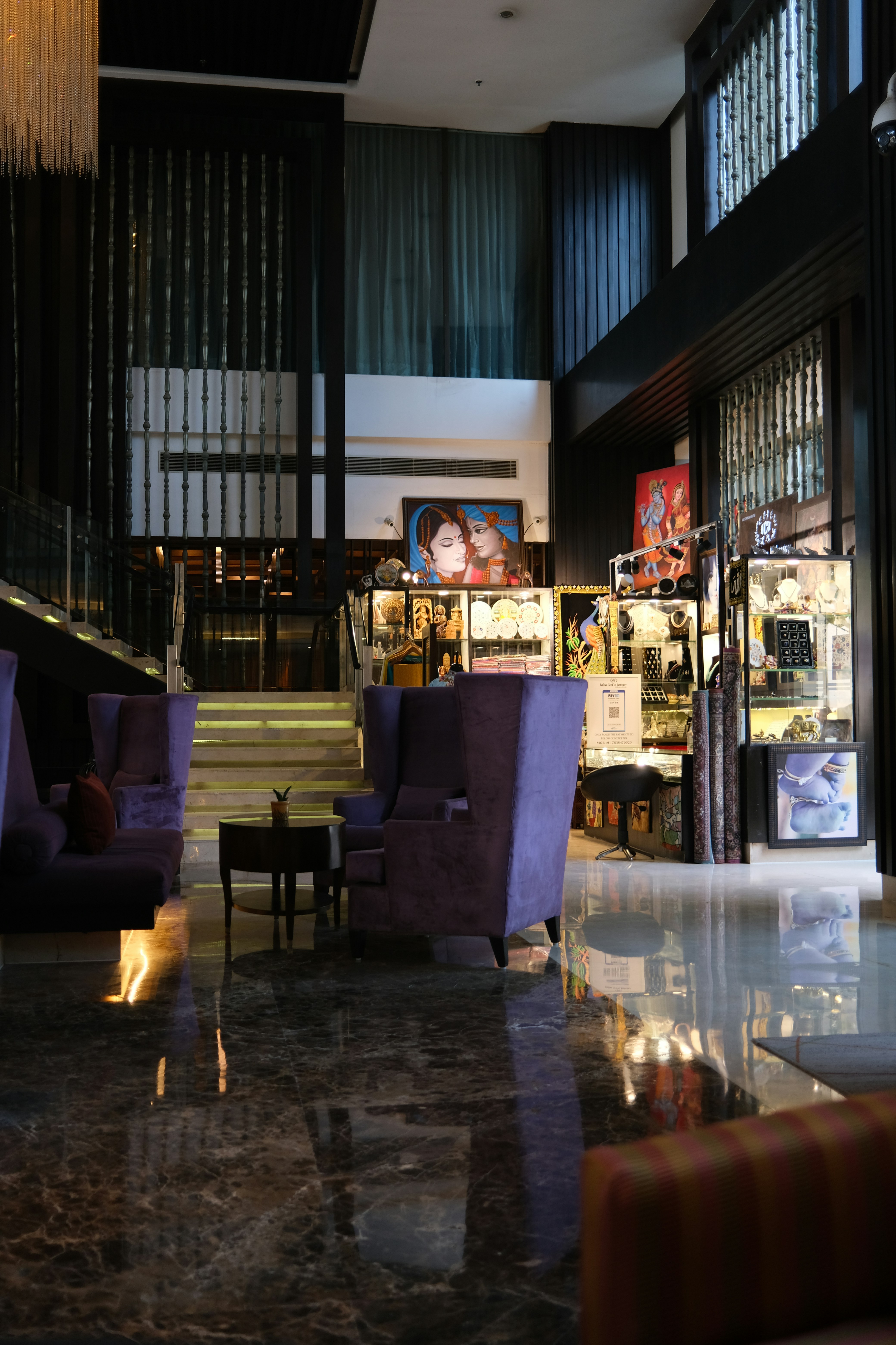 the lobby of a hotel with purple chairs