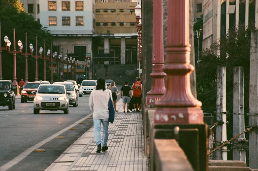 a group of people walking down a street next to tall buildings