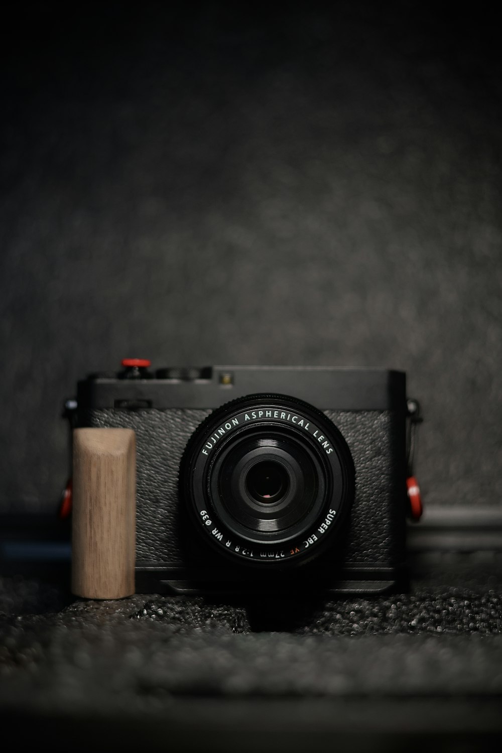 eine Kamera sitzt auf dem Boden neben einem Holzblock