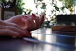 A set of glossy red nails with subtle glitter highlights on a wooden table.