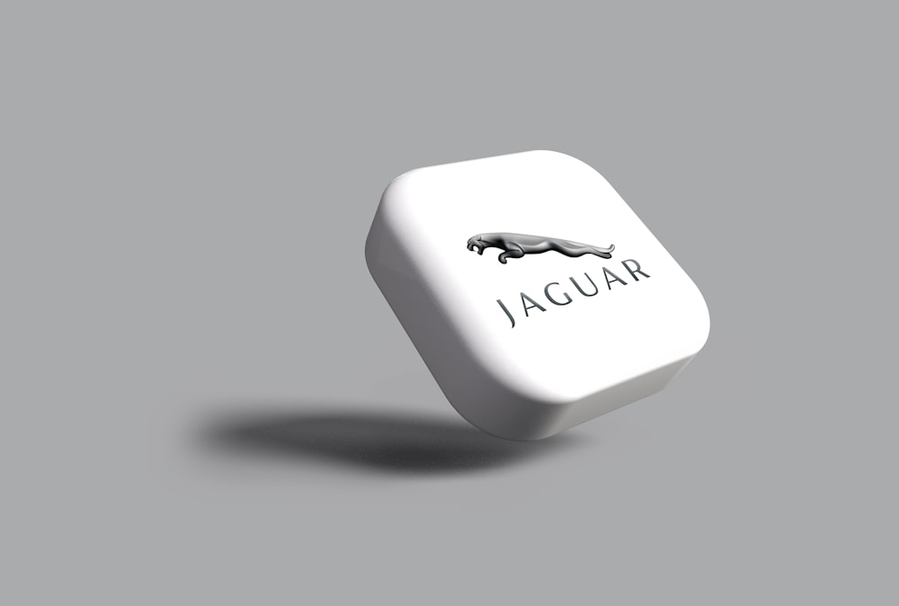 Un dé blanc avec un logo jaguar noir dessus