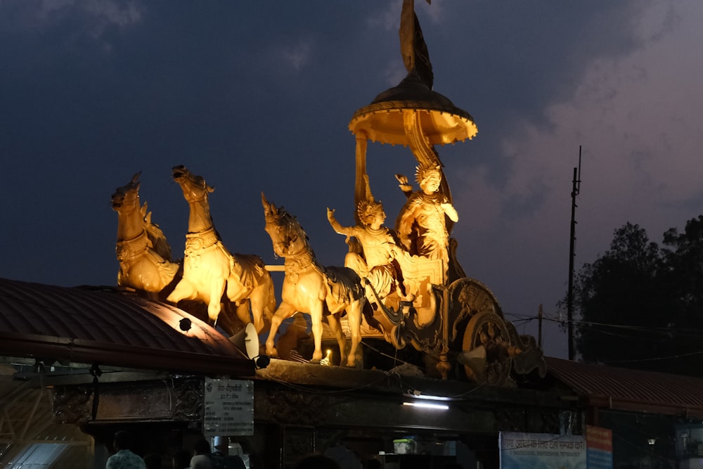 a statue of a group of people riding horses in front of a building