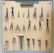 A pegboard is neatly organized with various tools, including scissors, pliers, hammers, and other hand tools. Each tool is secured on the board with a white strap. At the top, a label reads 'TOOLS OF THE TRADE'. The arrangement is symmetrical and orderly, with tools of different shapes and sizes.