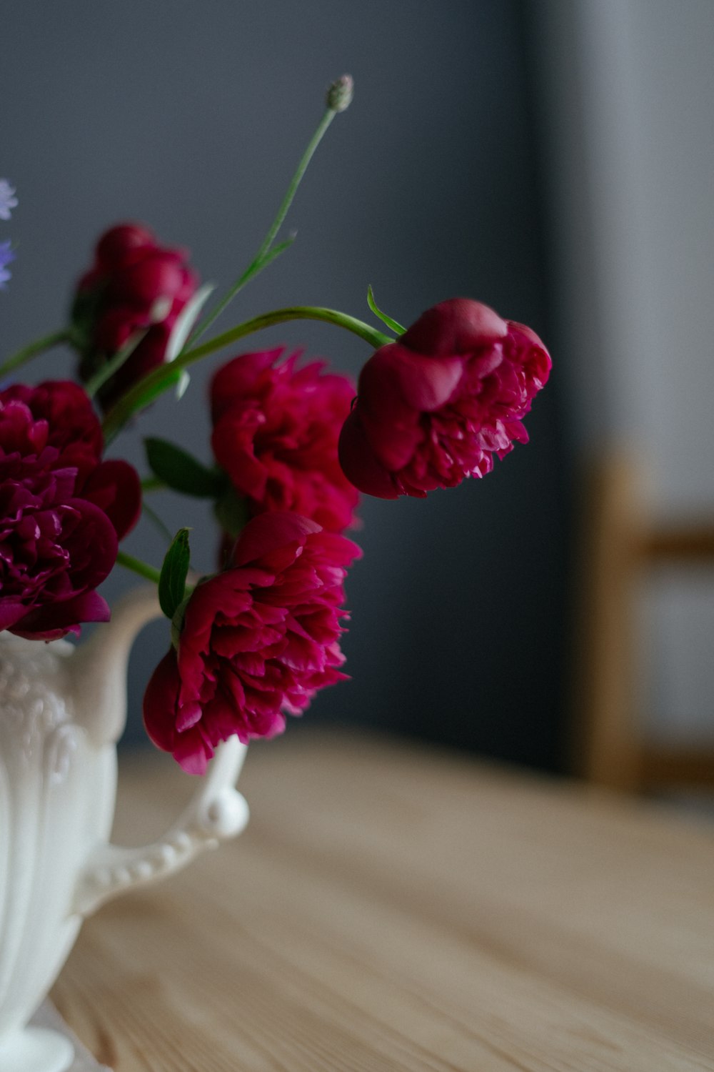 a close up of a vase with flowers on a table