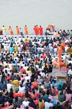 a large group of people standing around a body of water