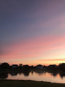 A serene landscape showing a sunset over a peaceful neighborhood.