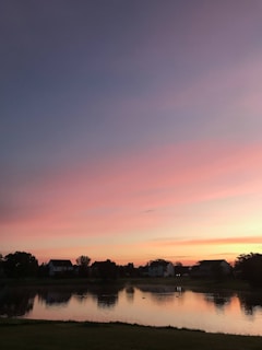 A serene landscape showing a sunset over a peaceful neighborhood.