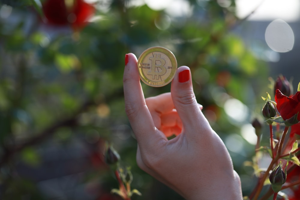 a person holding a bit coin in their hand