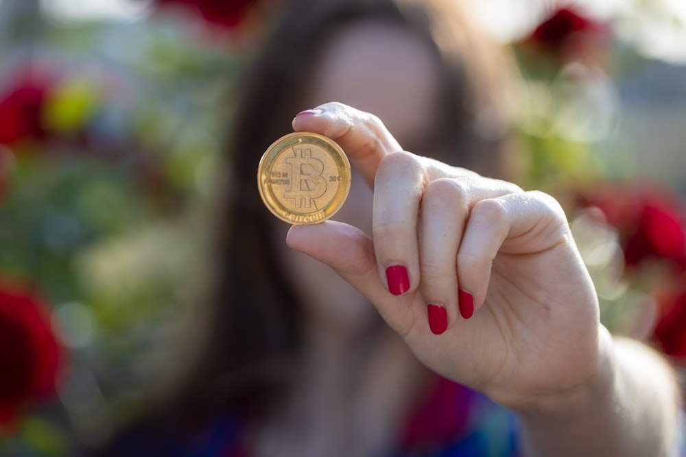 a woman holding a bit coin in her hand