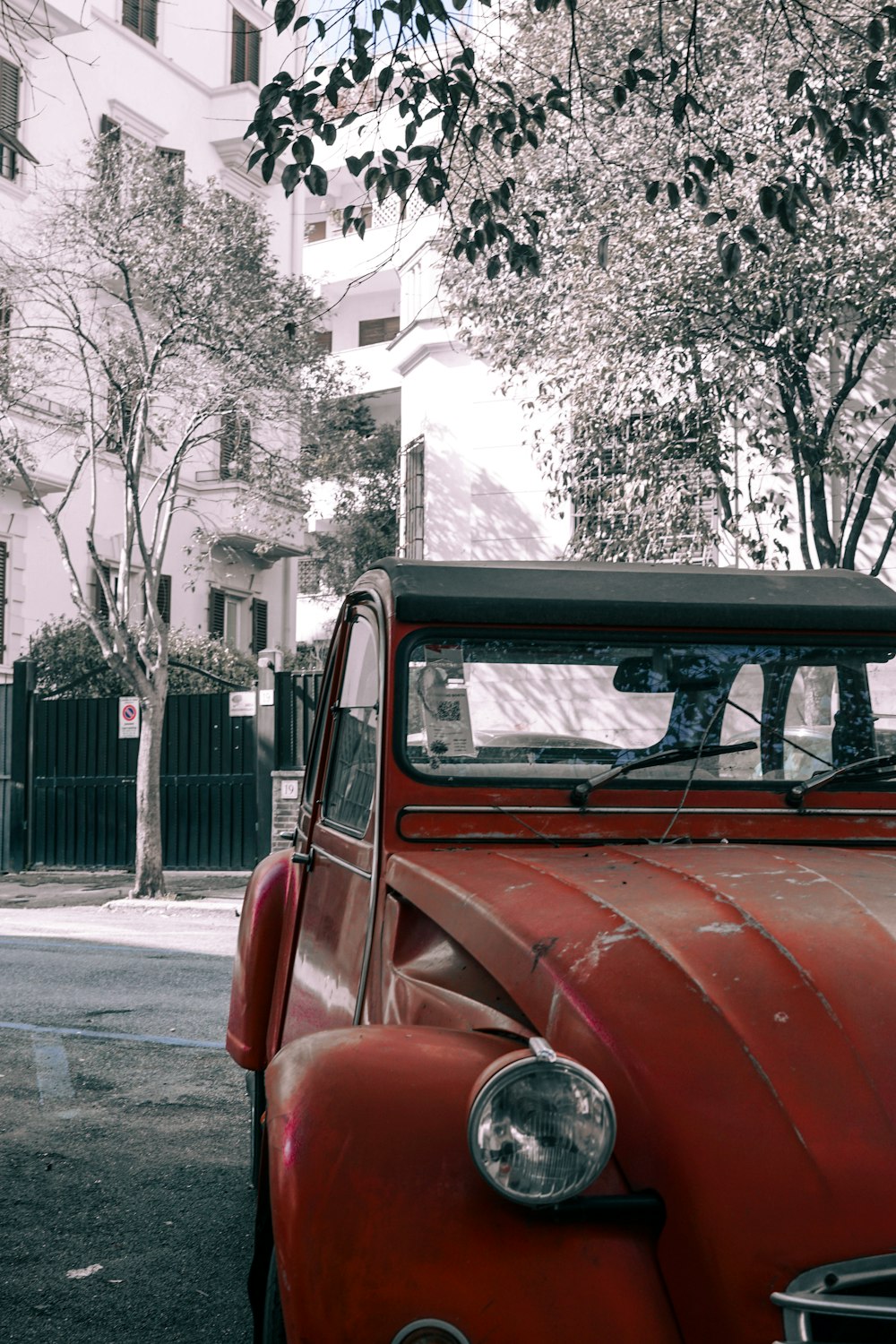 an old red truck parked on the side of the road