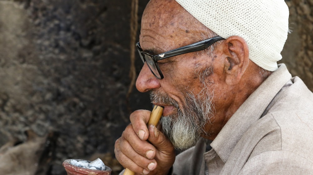 a man with a white turban is smoking a pipe
