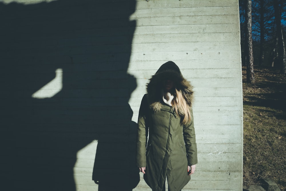 a woman standing in front of a shadow of a building