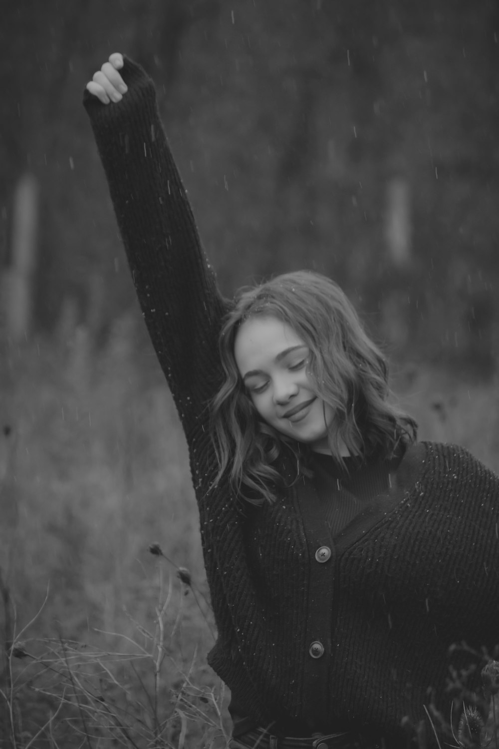 a woman standing in a field with her arms in the air