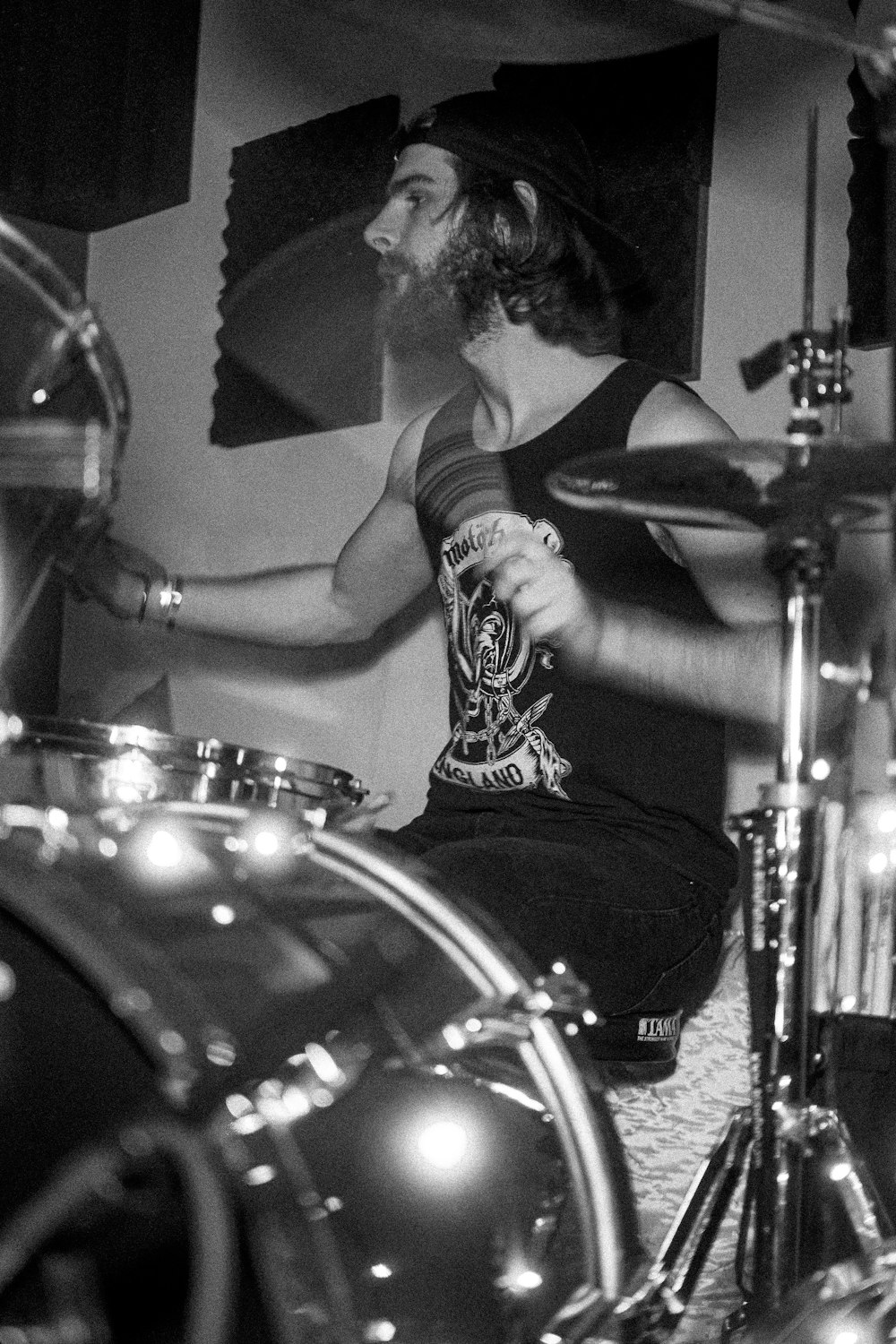 a man with a beard sitting on a drum set