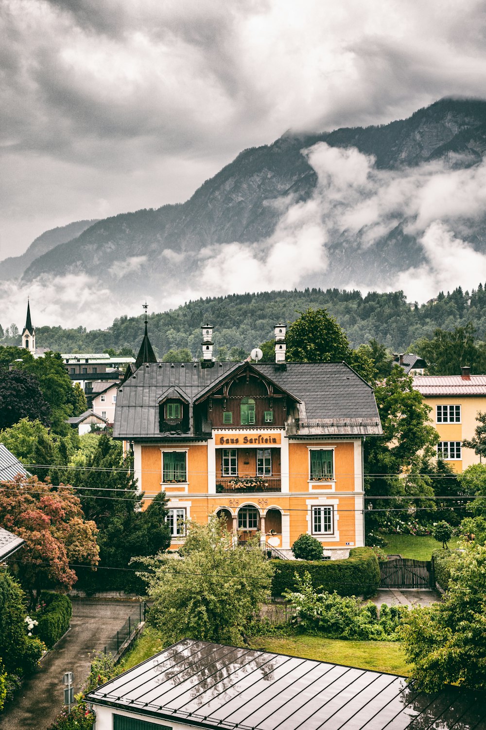 a yellow house with a mountain in the background