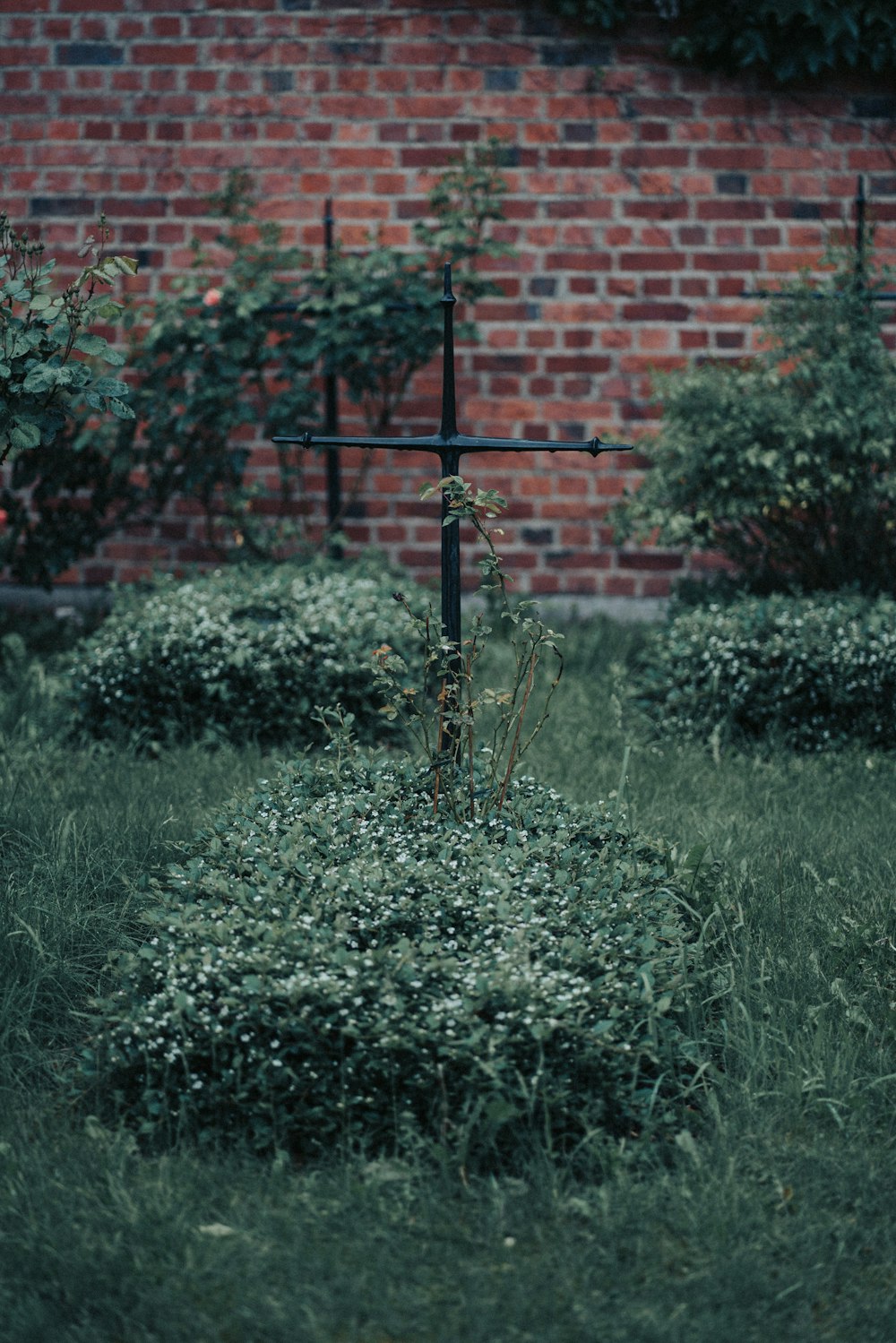 a cross sitting in the middle of a field