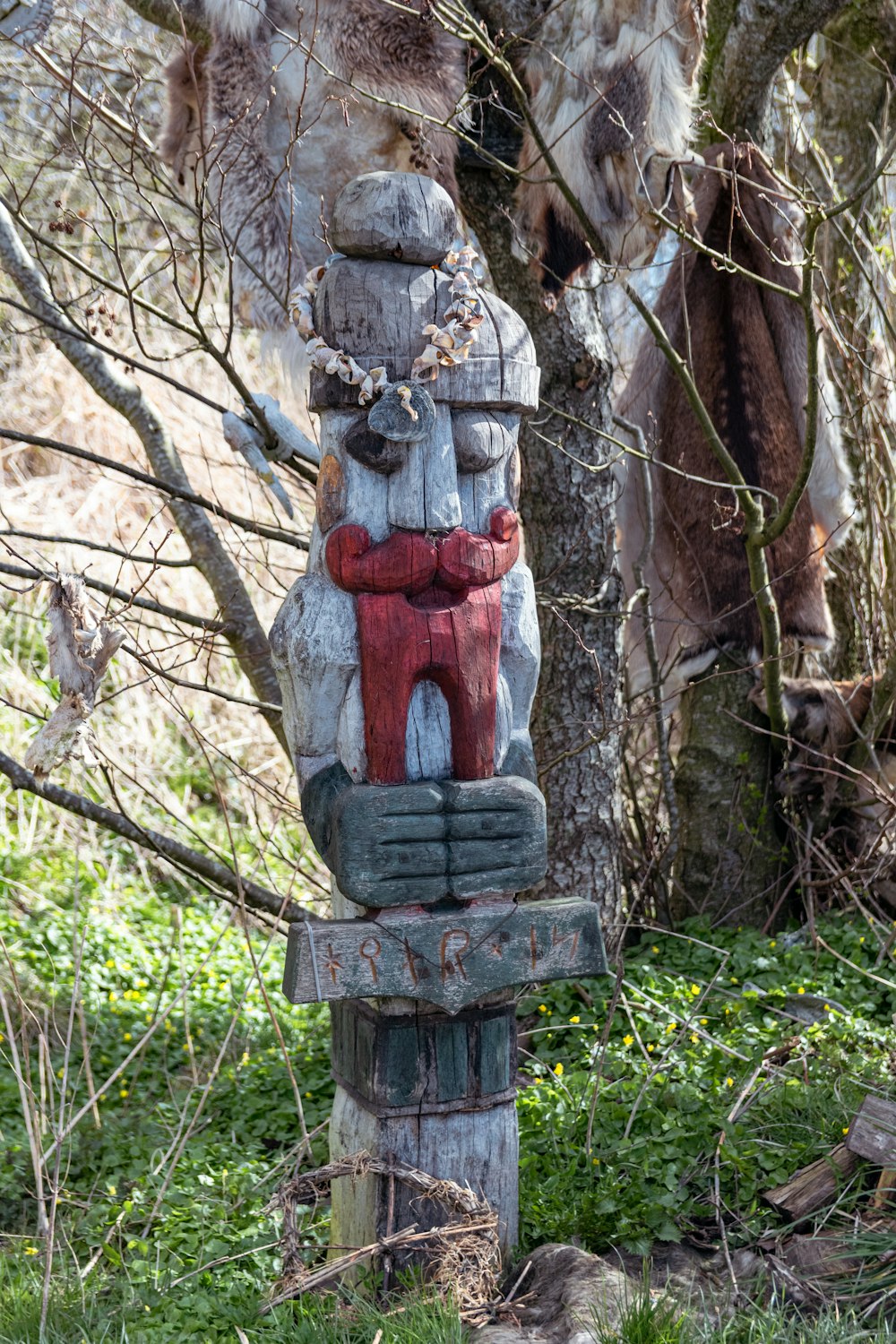 a statue of a person sitting on top of a wooden pole