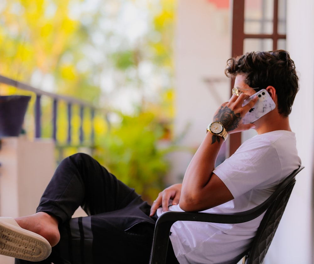 a man sitting in a chair talking on a cell phone