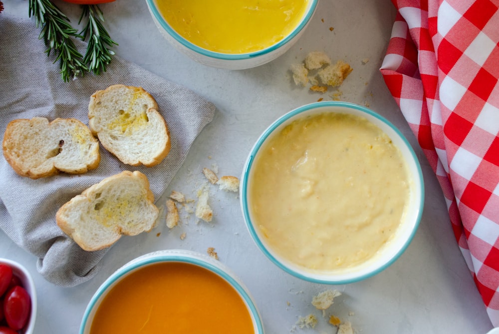 a table topped with bowls of soup and bread