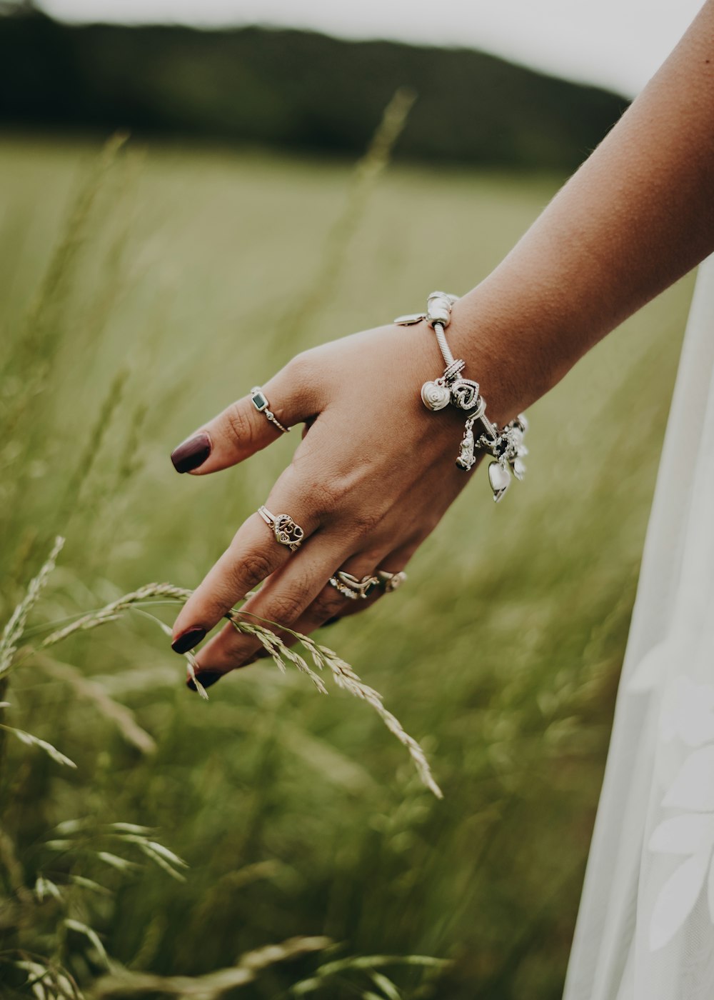 a woman's hand in a field of tall grass