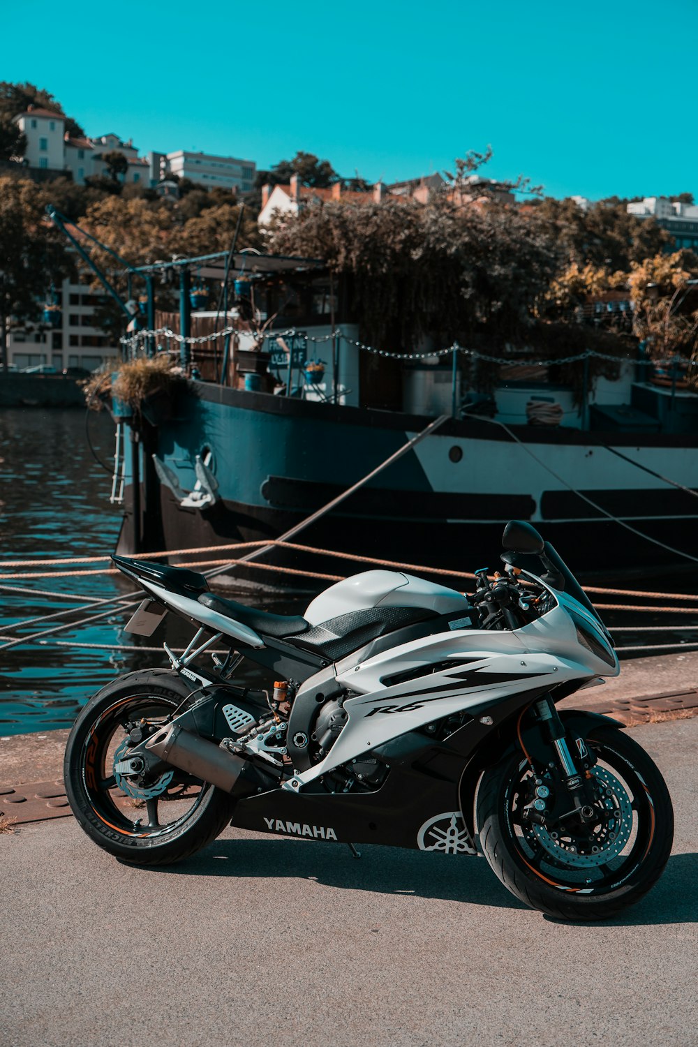 a motorcycle parked next to a boat in a harbor