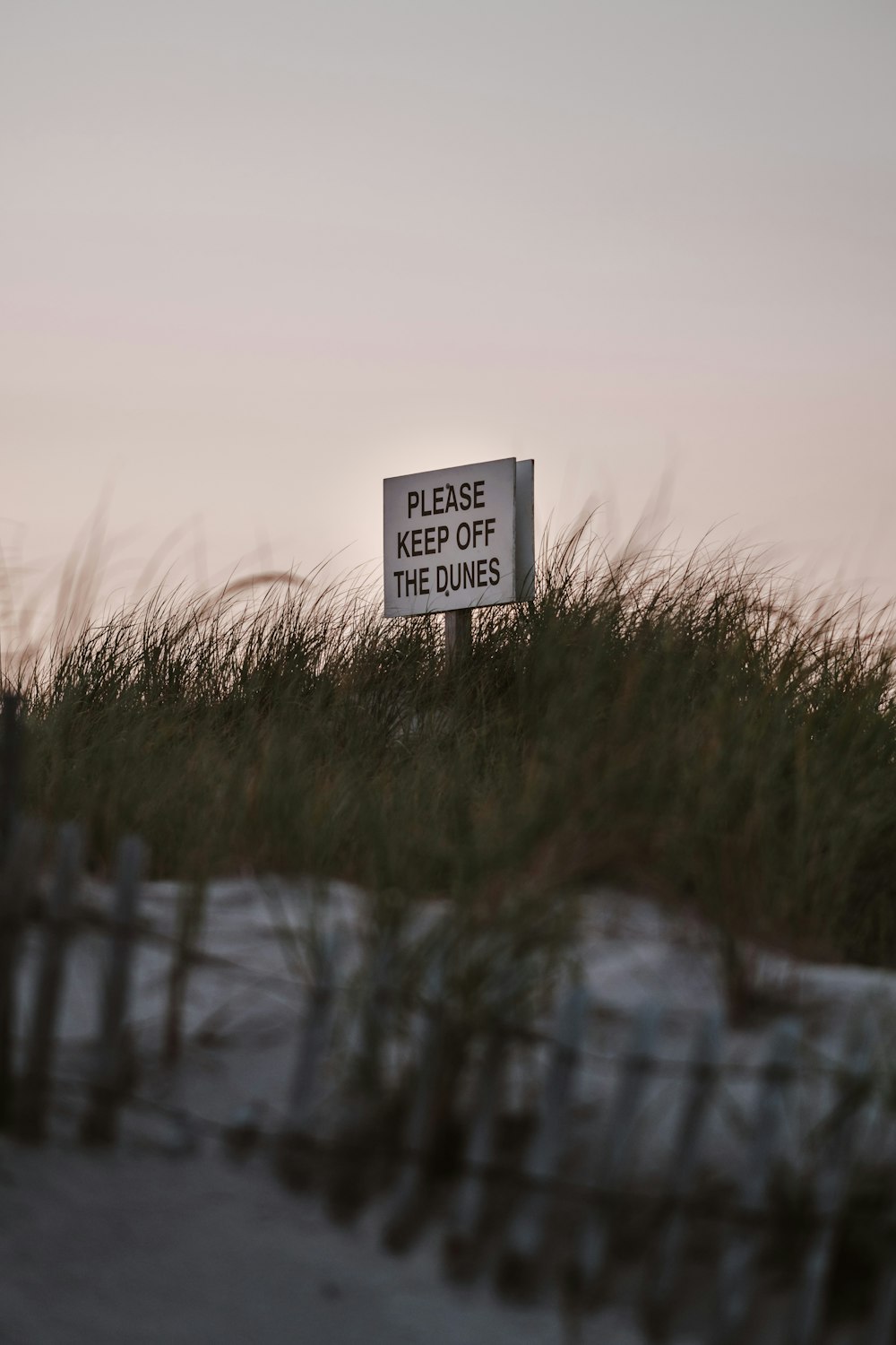 a sign that reads please keep off the dunes