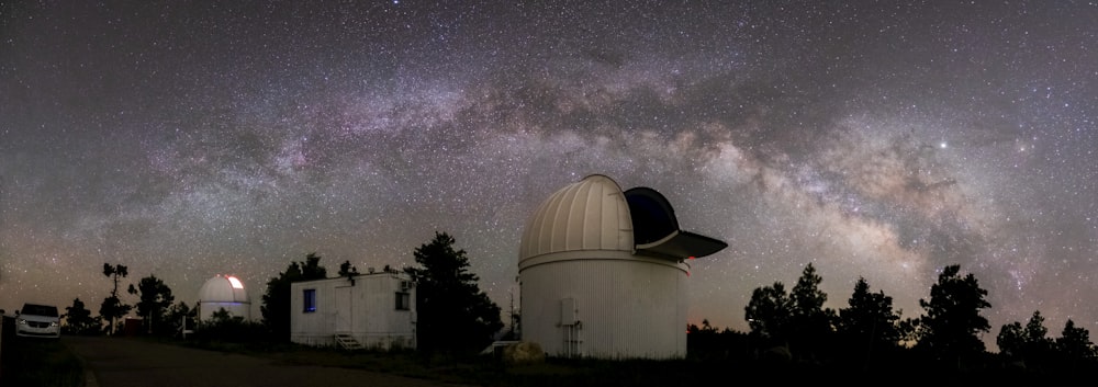 a large telescope sitting on top of a hill under a night sky filled with stars