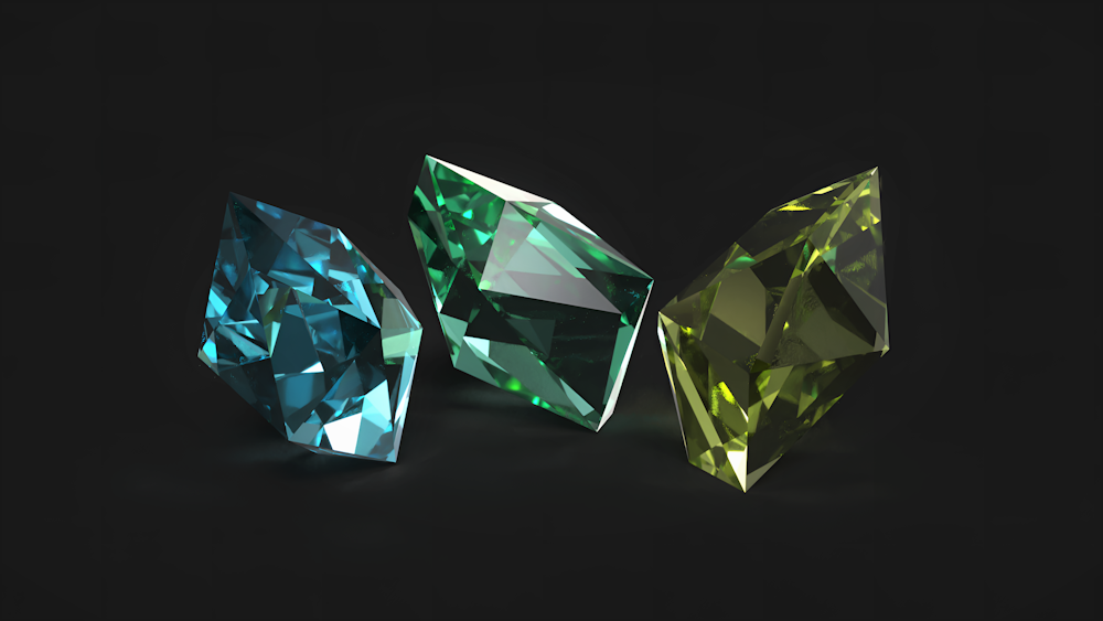 Tres diamantes de diferentes colores sobre un fondo negro