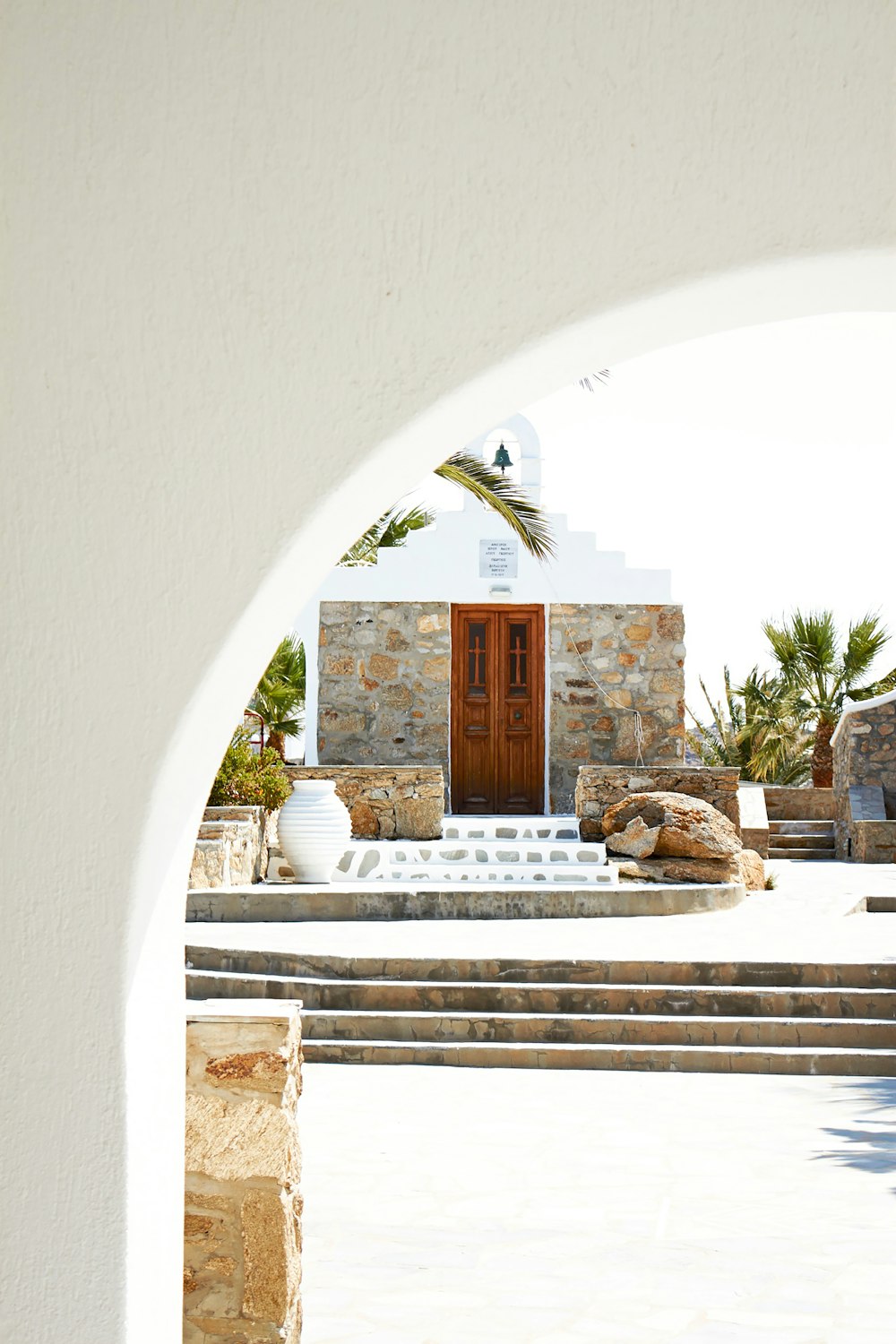 a white building with a brown door and steps