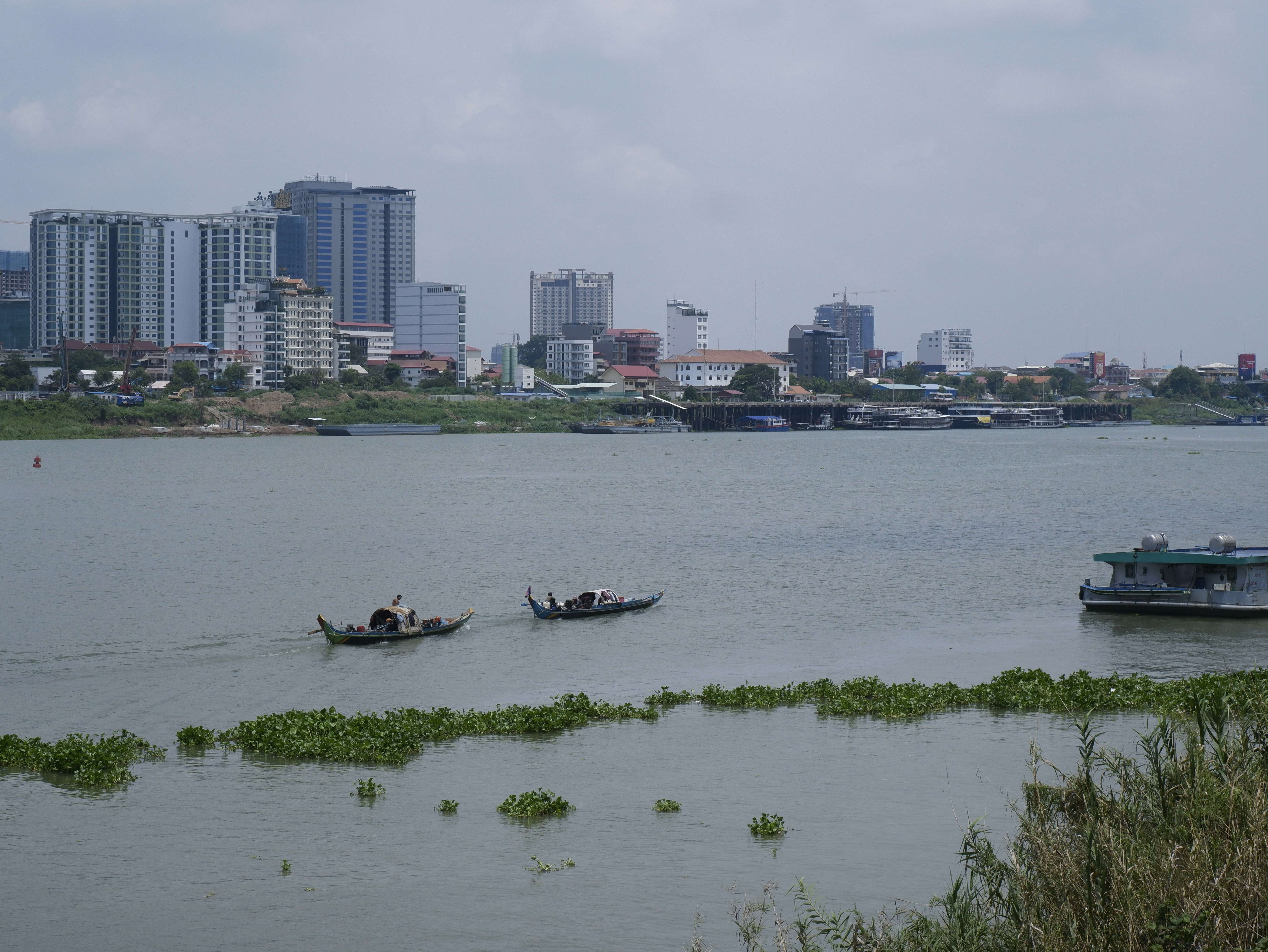 a small boat in a body of water with a city in the background