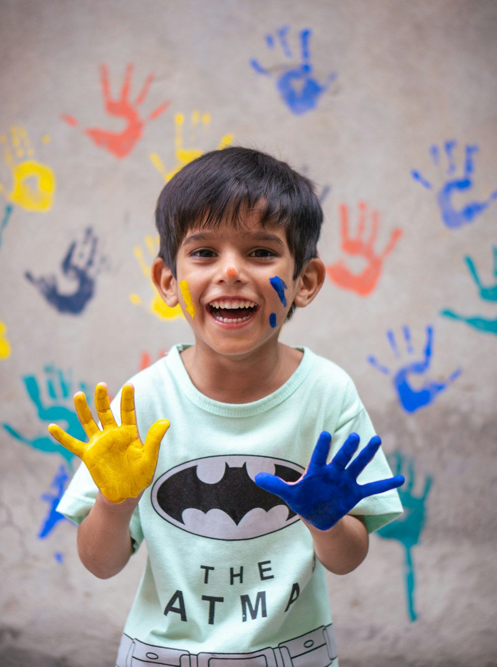 a young boy with his hands painted in blue and yellow