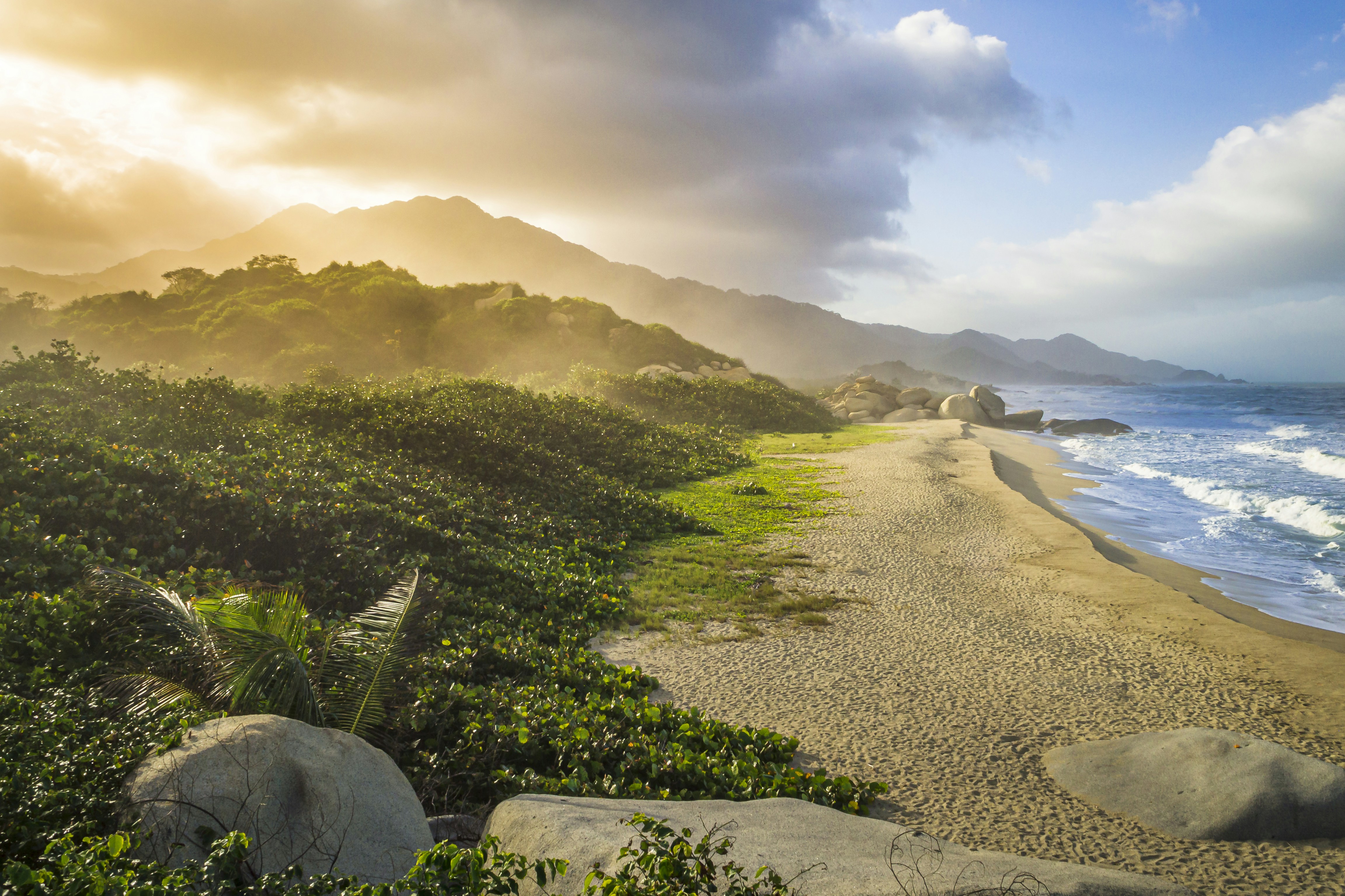 the sun is shining over the ocean and a beach