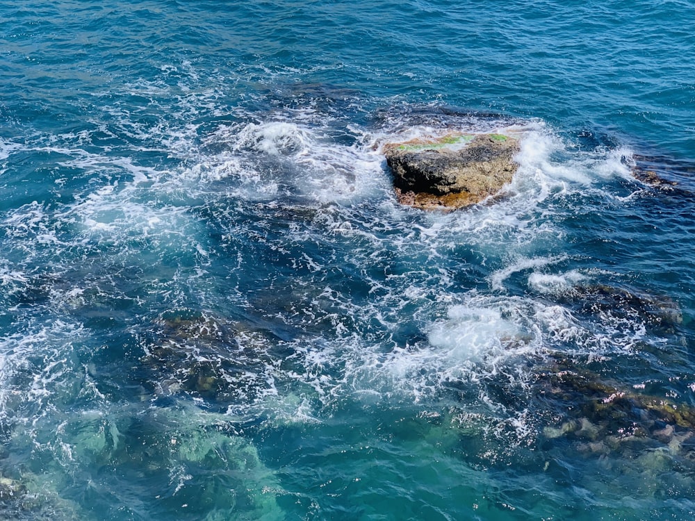 a large rock in the middle of a body of water