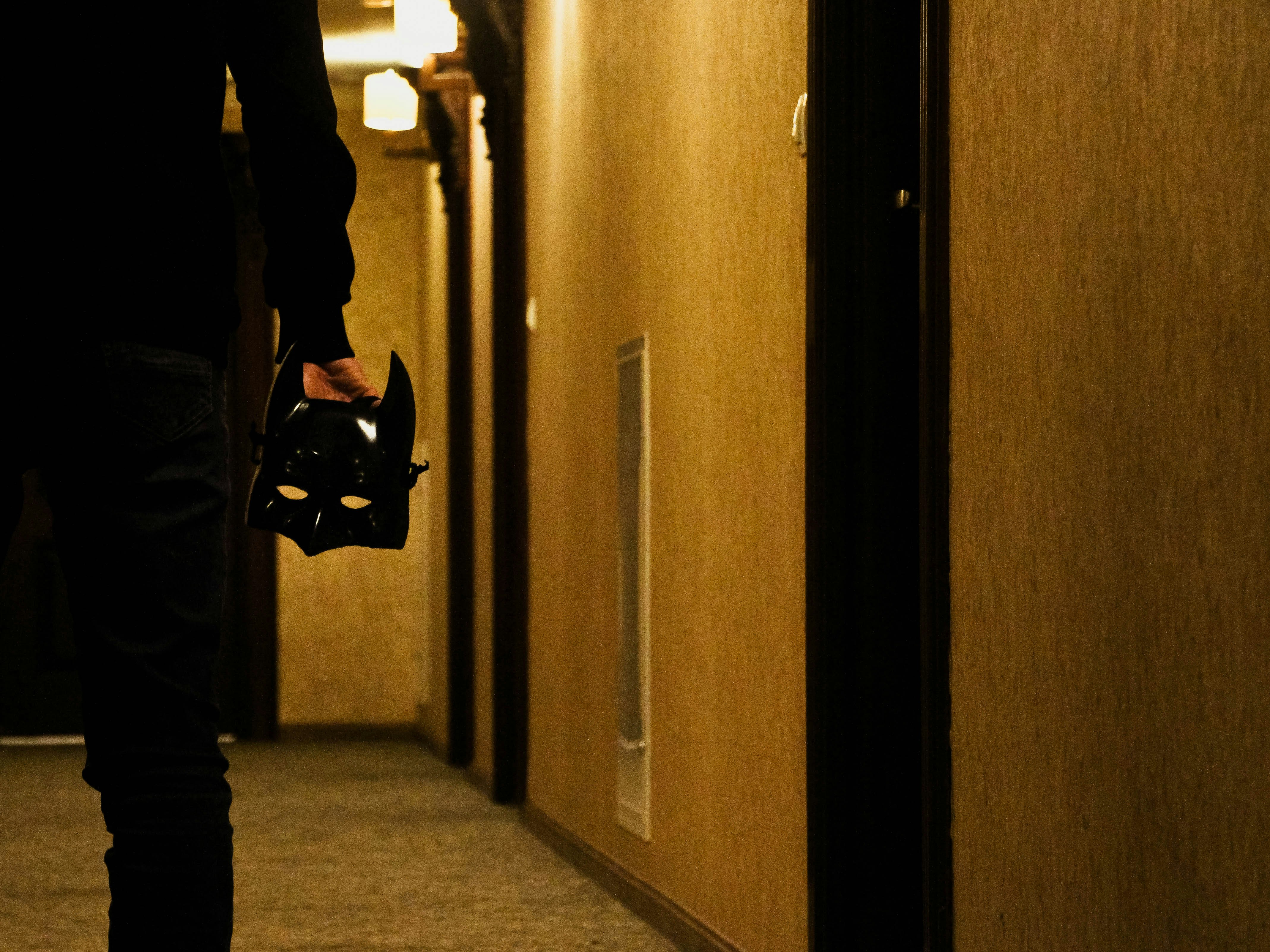 Una persona che cammina lungo un corridoio con una maschera di Batman