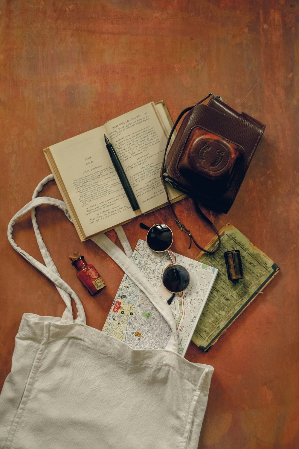 um saco, um livro, uma caneta e um par de óculos em um